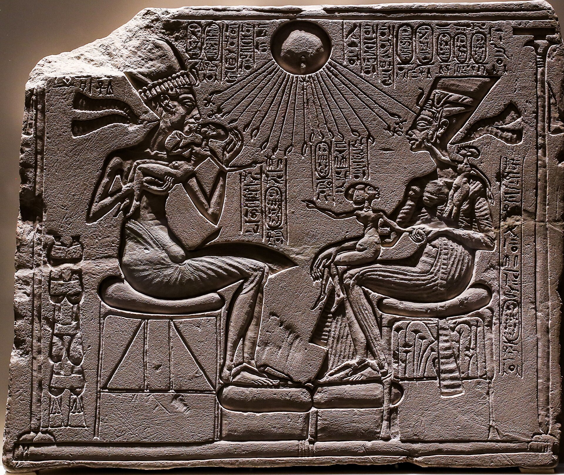 object type: relief from a shrine - description: Akhenaton and Nefertiti seated, holding 3 of their daughters, under the rays of the sun god Aton giving Ankh-symbols to them - production place: Achet-Aton / Amarna - peri