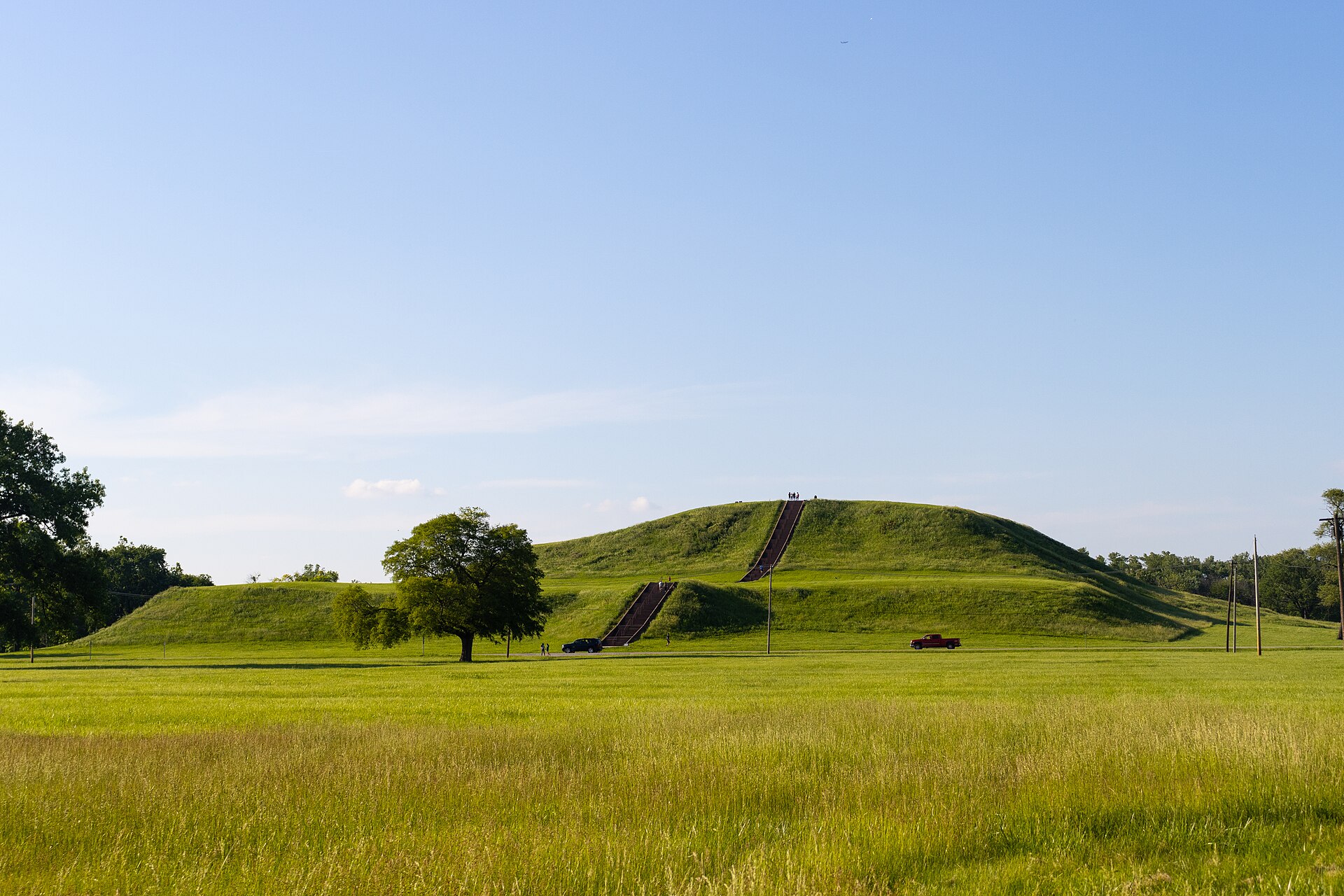 Photo taken in May 2024, facing the staircase side of Monks Mound. People and vehicles can be used to judge the size of this ancient structure.