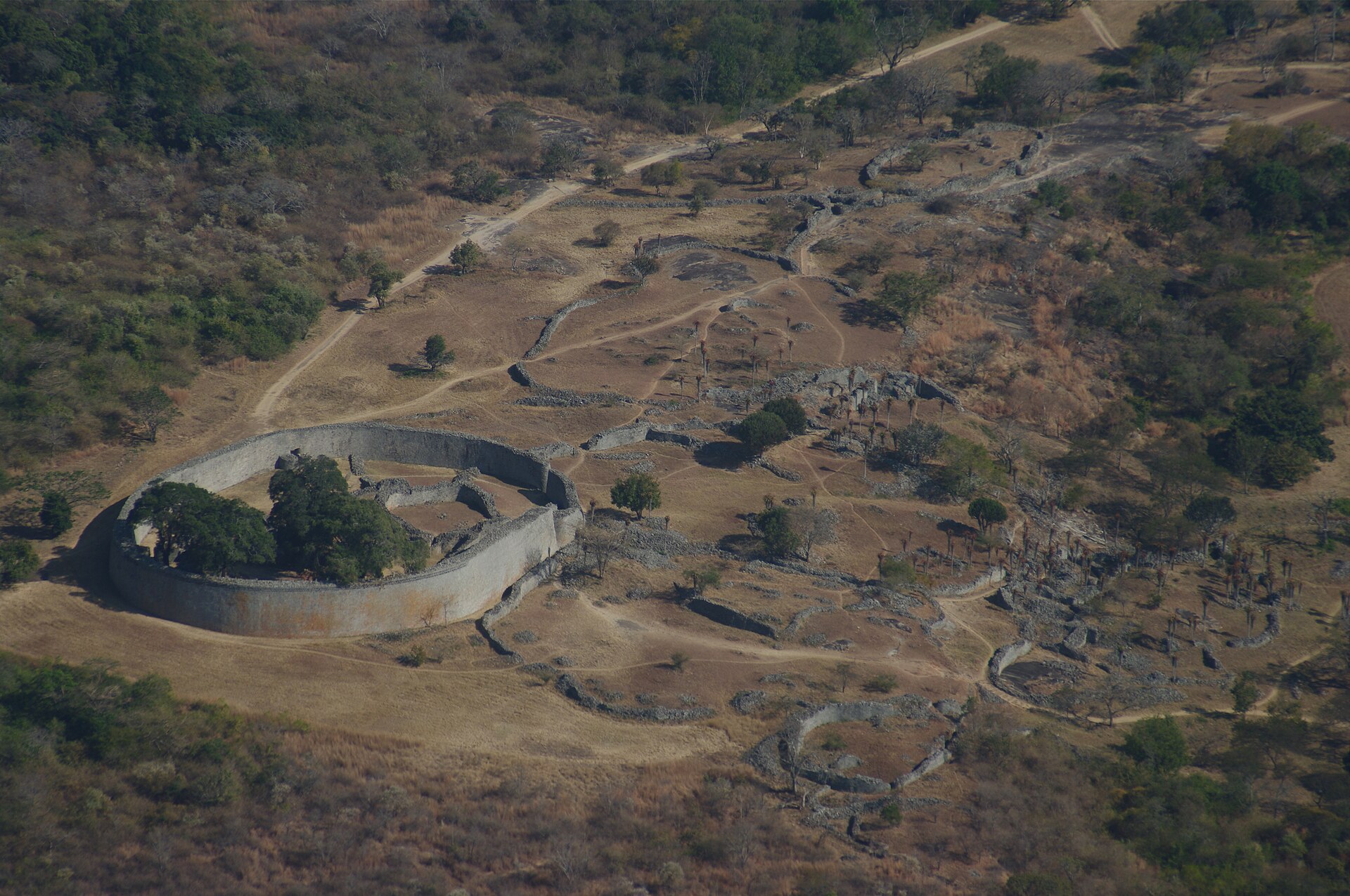 Aerial view of Great Zimbabwe's Great Enclosure (circumference 250 m, maximum height 11 m)[1] and adjacent ruins looking southeast from the Hill Fort.