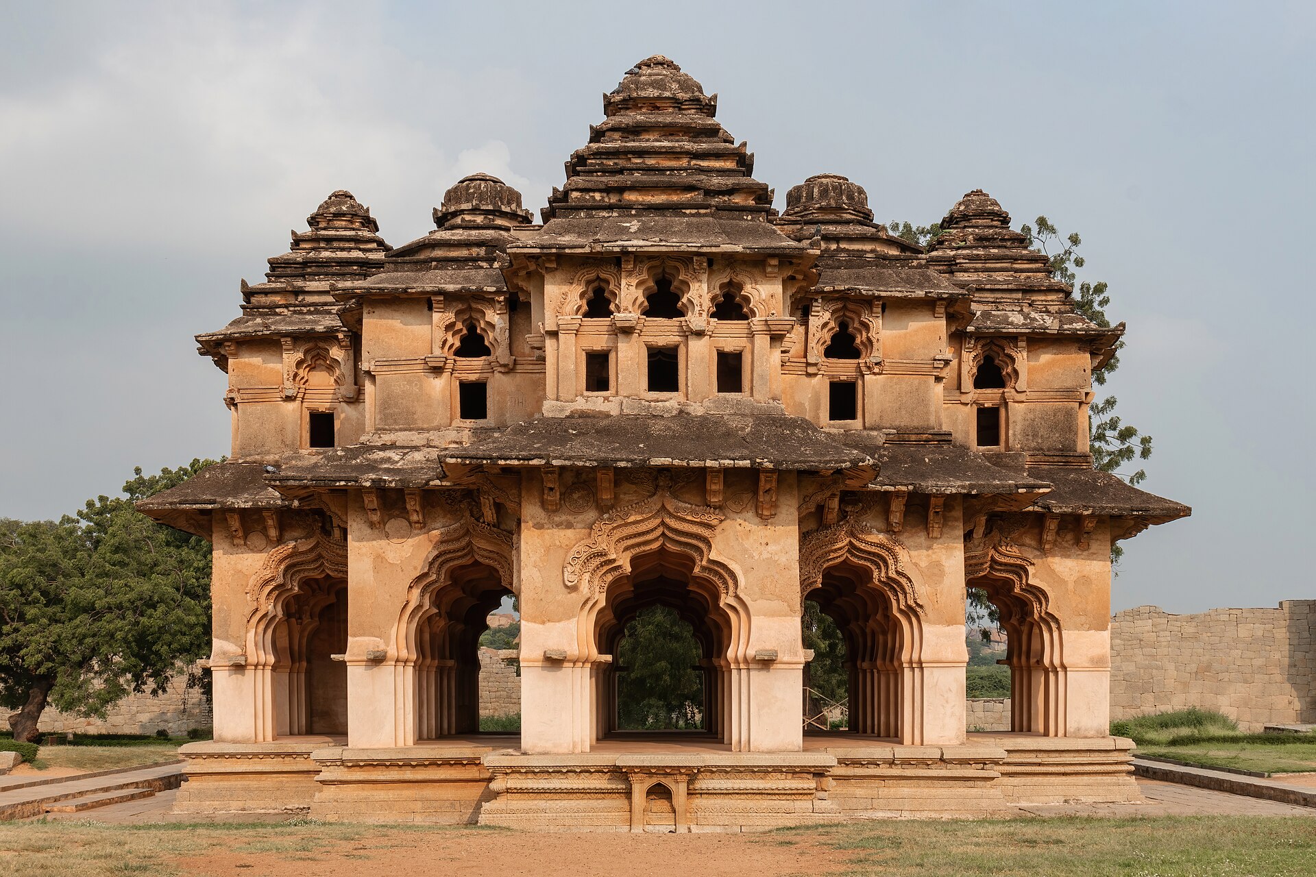 The image presents a flat elevation close-up of the Lotus Mahal in Hampi, showcasing its intricate architectural details. This view highlights the Mahal's distinctive lotus motifs, elegant arches, and ornate stonework, r