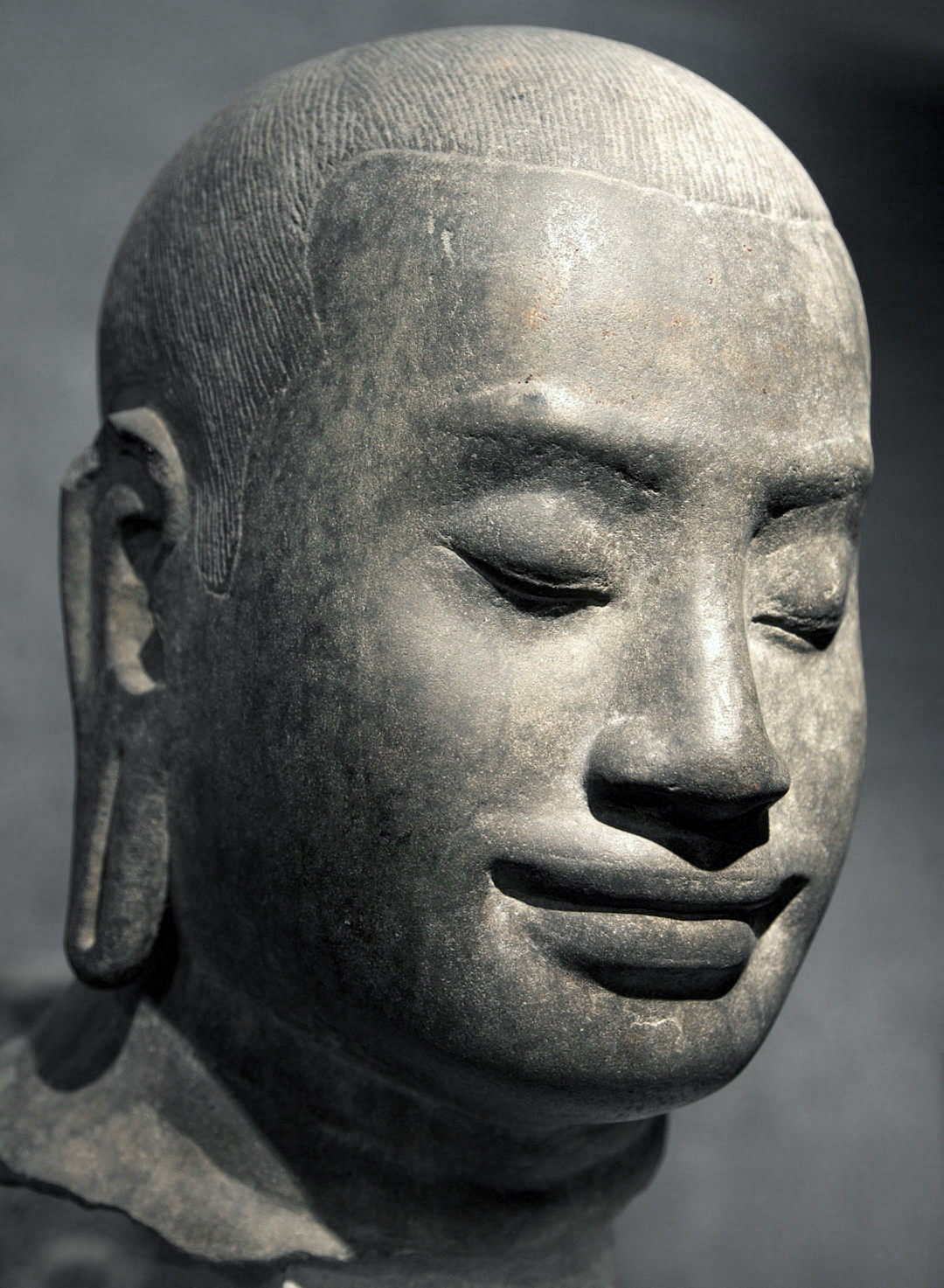 Tête présumée du roi Jayavarman VII. Ta Prohm (?) (Angkor). Style du Bayon, fin XIIe siècle. Grès. H. 42 cm ; L. 25 cm. ; P. 31 cm. P 430. Musée Guimet, Paris