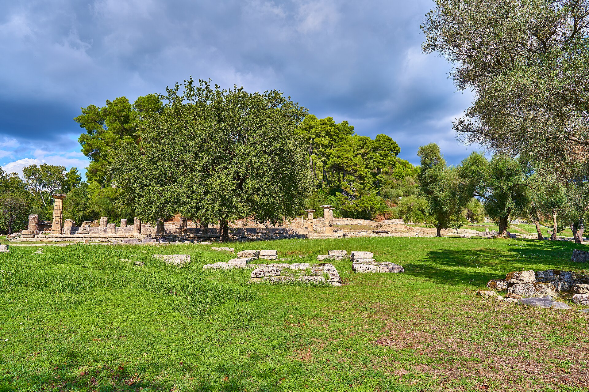 Remains of the Pelopeion in Olympia. In the background, the Temple of Hera and Kronion Hill.